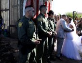 صور.. حفل زفاف على الحدود الأمريكية المكسيكية خلال فتح بوابة بالجدار العازل