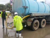 صور.. معدات حى شرق بالإسكندرية وشركة الصرف الصحى تشفط تراكمات المياه