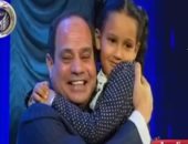 الرئيس السيسى يحمل طفلة شهيد خلال تسليمها وسام والدها بعيد الشرطة