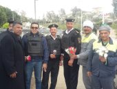 صور.. عمال نظافة الجيزة يوزعون الورود على ضباط الشرطة