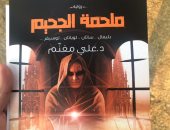 بميدالية وبوستر.. روائى يروج لروايته بمعرض القاهرة للكتاب