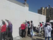 صور.. طلاب فنون تطبيقية بجامعة حلوان يحولون أسوار شارع السودان للوحة فنية