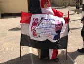 السيسى ومحمد صلاح فى لافتة واحدة بيد سيدة تدلى بصوتها بمصر الجديدة