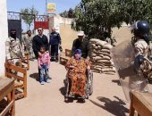 صور.. مجند يساعد سيدة معاقة للإدلاء بصوتها فى الانتخابات بالقليوبية