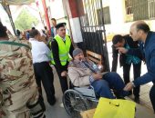 صور.. رجال الشرطة يساعدون كبار السن أمام اللجان الانتخابية