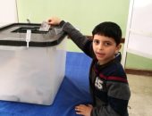 طفل يضع ورقة الاقتراع الخاصة بوالده فى الصندوق: بحب السيسى