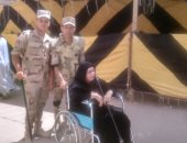 صور.. رجال الجيش يساعدون عجوز للإدلاء بصوتها فى حدائق حلوان