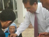 صور.. نائب رئيس الزمالك يسمح لإحدى المسنات بالإدلاء بصوتها خارج اللجنة