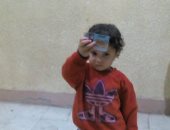 صور .. طفل يحمل بطاقة تحمل شخصية السيسى ويصر على وضع يده فى الحبر