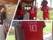 صور.. "مو صلاح" فى بلاد الدهب.. تى شيرت أبو مكة ينافس الأنتيكات والتحف بسوق معبد أبو سمبل السياحى.. الأجانب من كل مكان بيسألوا عليه ويحرصون على شرائه.. والباعة: عايشين فى خير أبو صلاح