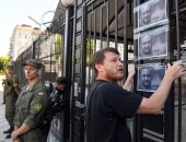 نشطاء يعلقون صور صحفى معارض قتل بأوكرانيا على سور السفارة الروسية