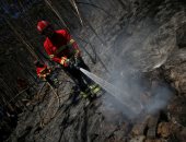 صور.. رجال الإطفاء يحاولون السيطرة على حريق الغابات بالبرتغال