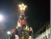 رأس السنة فى الكوربة غير.. شباب يتسلقون شجرة الكريسماس فى الكوربة 