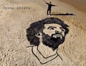 من قلب النضال.. فنان فلسطينى يرسم مو صلاح على رمال شاطئ غزة