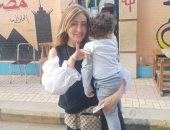 ريهام سعيد بصحبة ابنها أثناء الإدلاء بصوتها على التعديلات الدستورية