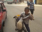 بالعجلة.. الطفل عصام يعمل فى نقل الخبز ببنى سويف لتوفير مصاريفه