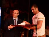 صور.. نائب محافظ بورسعيد يهدى بطل سيناء النقيب على الزينى "كتاب الله"