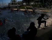 مواطنون أمريكيون يهربون من موجة الحر الشديدة باللعب فى الماء