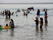 عراقيون يهربون من الحر الشديد بالسباحة فى بحيرة الحبانية