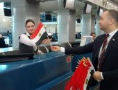 مطار القاهرة يحتفل بذكرى نصر أكتوبر بتوزيع علم مصر على الركاب.. صور 