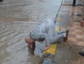 صور وفيديو .. رئيس مدينة مطوبس بكفر الشيخ " يُسَلّك " البلاعات لتصريف مياه الأمطار