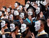 طلاب بأقنعة يهتفون بشعارات المحتجين فى حفل تخرجهم بهونج كونج