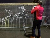 جدارية بانسكى "عيد الميلاد" تحت حماية الشرطة البريطانية بعد تشويهها.. صور