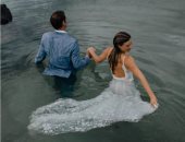 "عروسة البحر".. "فوتوسيشن" ساحر لزوجين فى قلب الماء بملابس الزفاف