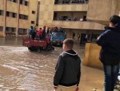 صور.. طلاب بالإسكندرية يدخلون اللجان بسيارات النقل لتراكم مياه الأمطار