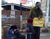 "سيبها علينا" أسرة بكفر الشيخ تحمل لافتة "يا أهل الخير أسرة فى الشارع"
