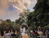 فوتو سيشن مجنون.. عروسان يلتقطان صور زفافهما أثناء ثوران بركان فى الفلبين