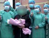 مرضى تعافوا من كورونا يلتقطون صورا مع الأطقم الطبية بمستشفى صيني.. فيديو