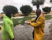 صور.. رئيس جهاز برج العرب يقدم الحلوى للعمال أثناء رفعهم مياه الأمطار 