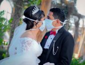 العروسان "أنطونيوس ونانسى" يواجهان كورونا بالمنيا بارتداء الكمامة وحمل الكلور