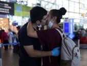 قبلة حارة تتحدى فيروس كورونا فى مطار عاصمة تشيلى