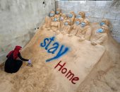 نحاتة فلسطينية تحث الناس على البقاء فى منازلهم من خلال "النحت على الرمال"
