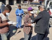 رئيس مدينة رأس غارب يوزع كمامات على عمال النظافة بالشوارع.. صور