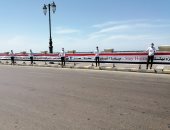 صور .. شباب يحملون علم مصر على كوبرى "ستنالى" ويرفعون شعار " خليك فى البيت"