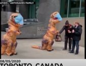 فيديو.. أم كندية وابنتها يرتديان زى ديناصور ويوزعان الكمامات مجاناً