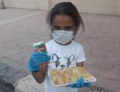 "لميس" أصغر طفلة متطوعة فى مبادرة "إفطار صائم" وهى ترتدى الكمامة بالأقصر