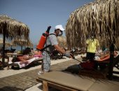 اليونانيون يعودون للشواطئ وسط موجة حارة مع مسافات بين المظلات خوفا من كورونا