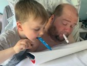 أب " قعيد" يستغل عزل كورونا لتعليم طفله الرسم بالفم .. صور