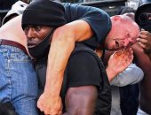 الكشف عن تفاصيل صورة حمل متظاهر أسود لآخر أبيض فى مظاهرات لندن