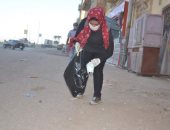صور.. فتاة أقصرية تجمع الكمامات المستعملة من الشوارع لحماية الأهالى