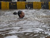 سيارات و"تكاتك" ورجال يسبحون في مياه الأمطار بالهند.. صور