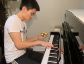 شاب يحل مكعب الروبيك ويعزف على البيانو فى وقت واحد .. فيديو