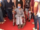 الشرطة تساعد مسنا بكرسى متحرك للوصول إلى لجنة بالقاهرة للإدلاء بصوته