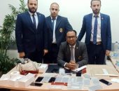 راكب بمطار القاهرة يحاول تهريب هواتف محمولة حول جسده.. صور