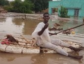 سودانى ينقذ كلاب صغيرة من الغرق فى مياه الفيضانات.. صور