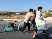 "جوعى وعطشى".. فرار آلاف اللاجئين بليسبوس اليونانية بعد حريق مخيم موريا.. ألبوم صور